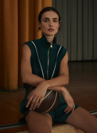 Varley Allena Half Zip Vest in Forest Model Holding a Basketball on her Lap