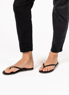 TKEES Lily Liners Flip Flops in Black Shown on Feet