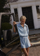 Varley Barnes High Rise Short 4.5” in Airy Blue Model Shown Opening a Car Door
