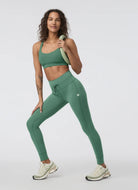 Vuori Daily Pocket Legging in Hedge Green Front View With Model in a Pose