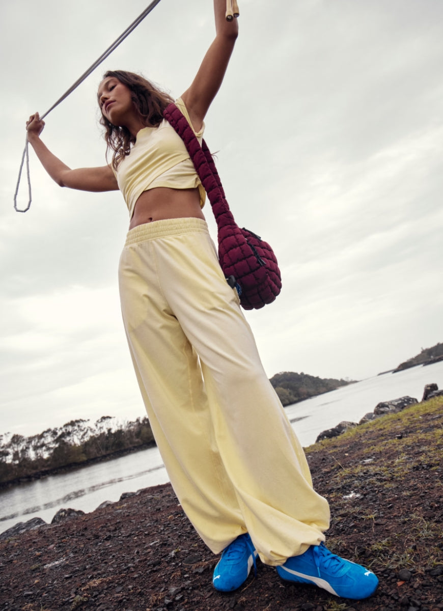 Free People Hot Shot Crossover Set in Sunlit Yellow Model Shown on Rocky Shoreline