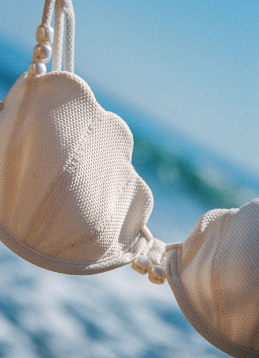LSPACE Sunrise Shell Bikini in Cream Shown Hanging With Ocean in the Background