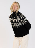 Lyla + Luxe Aggie Fairisle Crewneck Pullover Sweater in Black/White Front View Model With Hands Behind Her Back