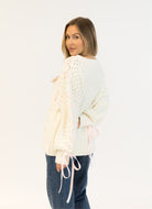 Lyla + Luxe Lydia Crewneck Pullover Sweater in White/Pink Ribbon Back View With Model Looking Over Her Shoulder