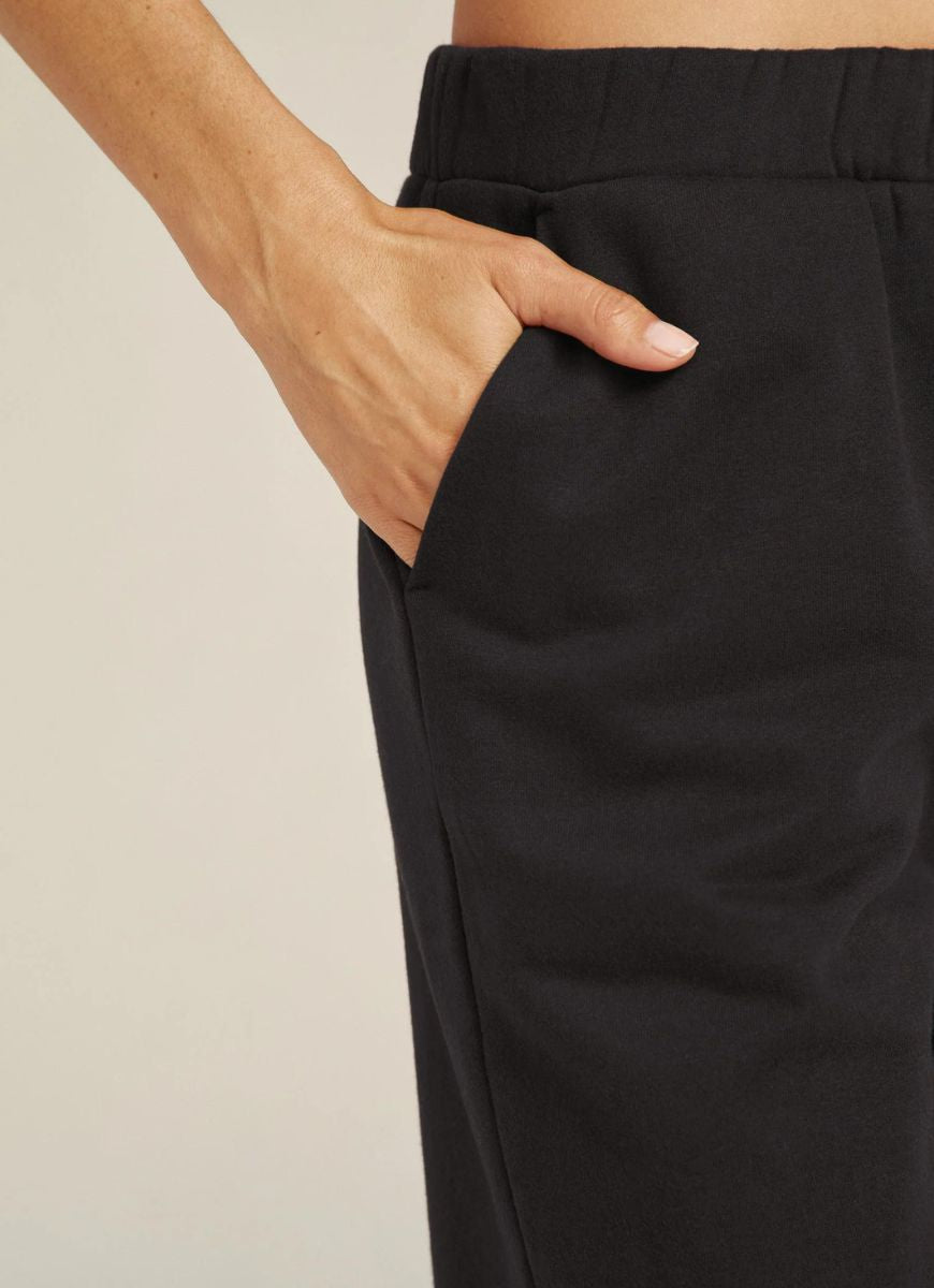 Beyond Yoga Women's On The Go Pant in Black Close Up View With Hand in Pocket