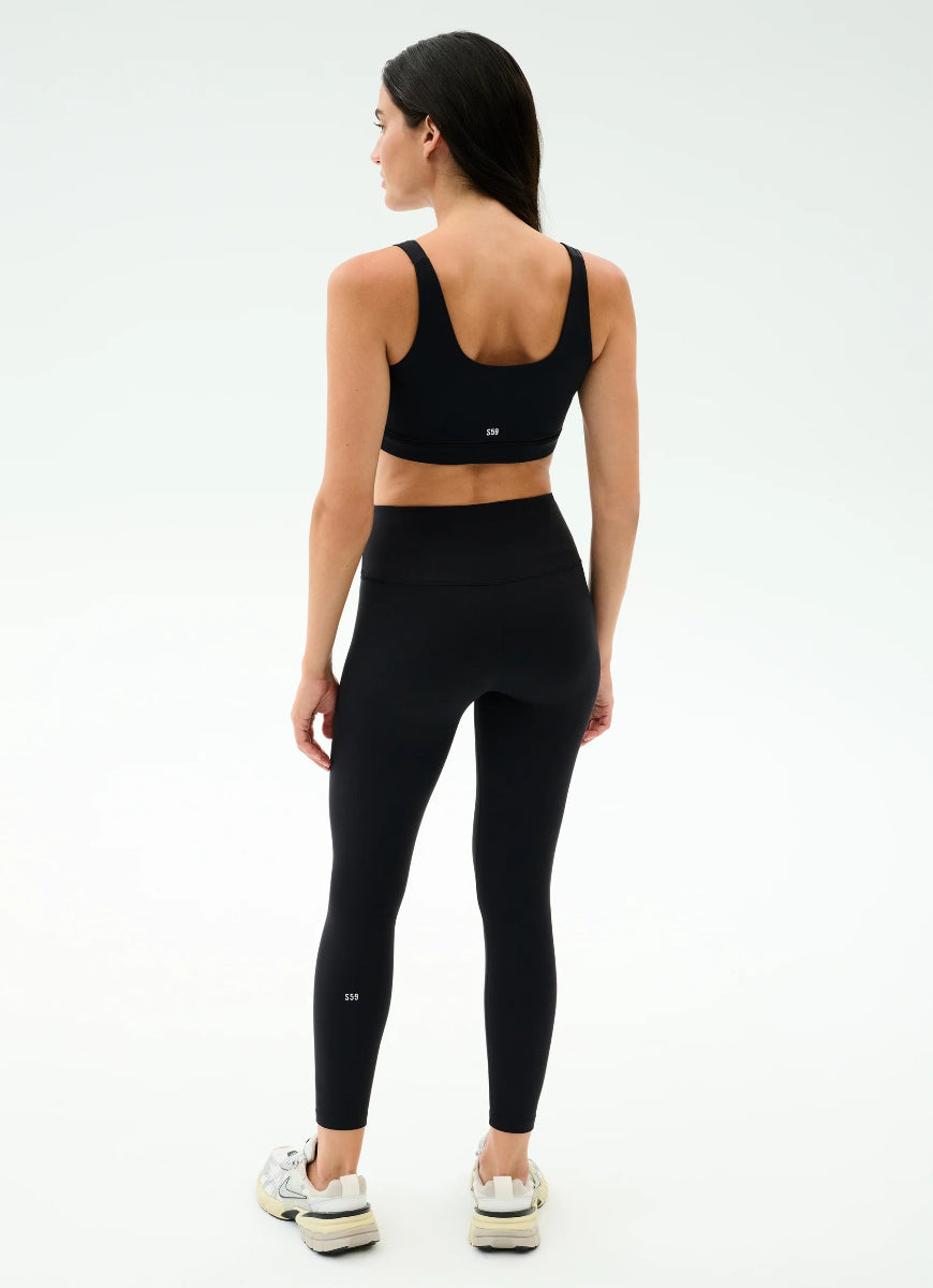 Woman wearing a black athletic outfit on a white background