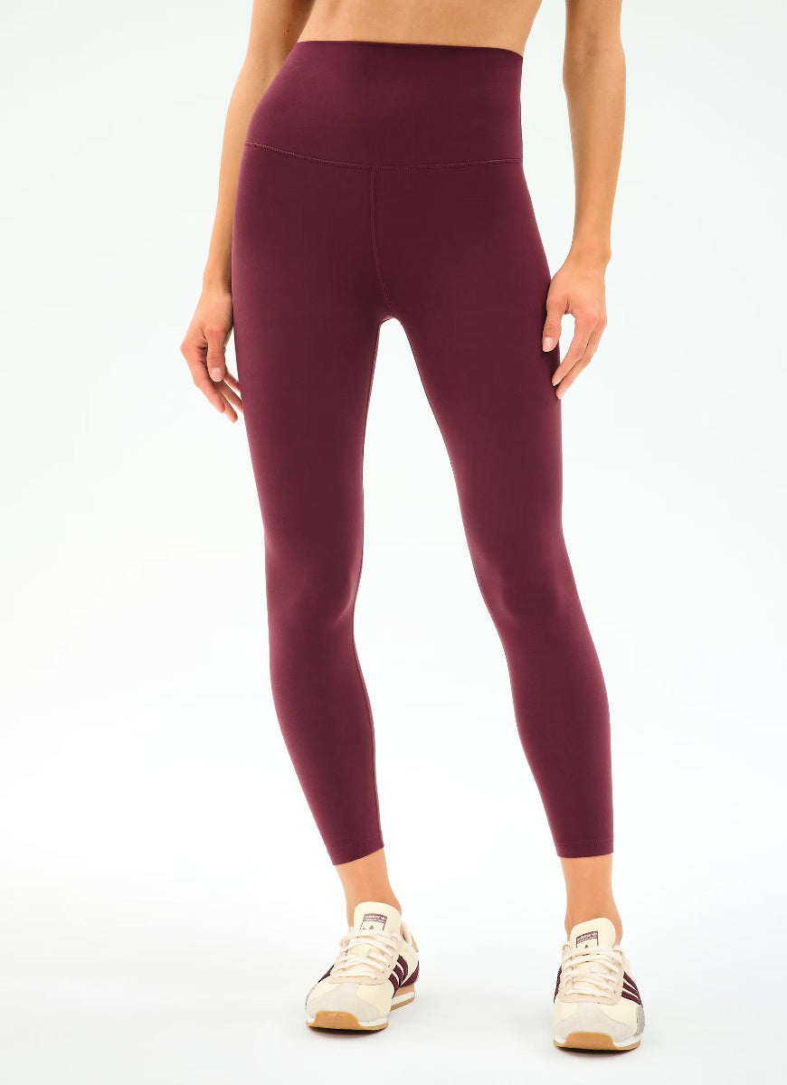 Maroon leggings worn by a person on a white background