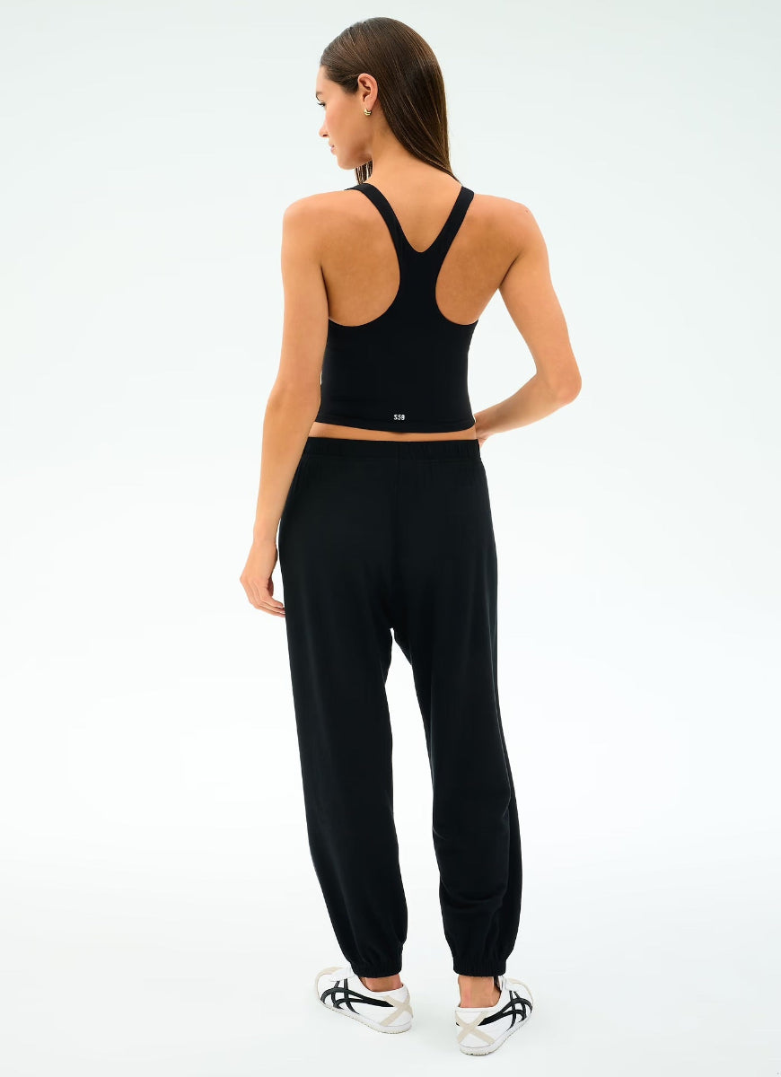 Woman wearing a black athletic outfit on a white background