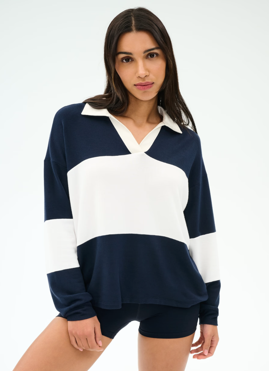 Woman wearing a navy and white color-blocked sweater on a plain background