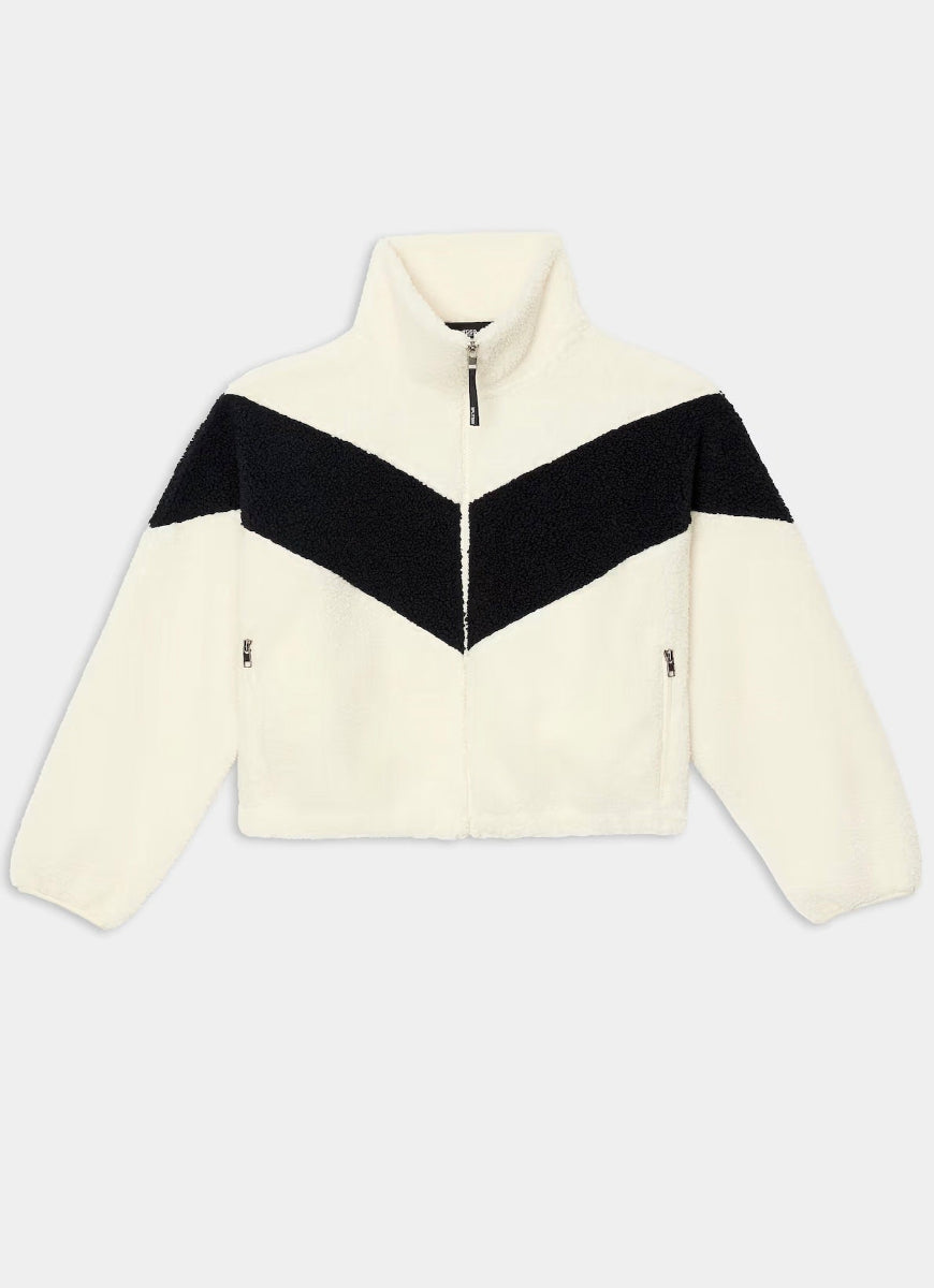 A cropped zip-up fleece jacket with a high collar, featuring a cream-colored body and sleeves with a contrasting black V-shaped chest panel, shown against a light gray background.