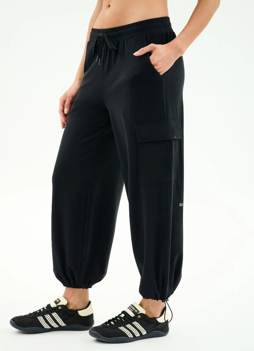 Person wearing black cargo pants with a white background