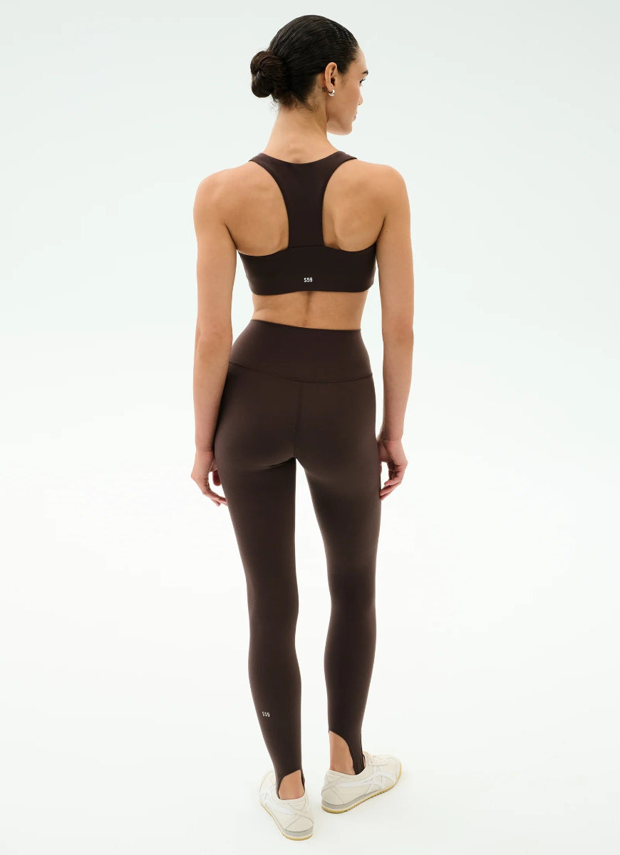 Person wearing a black sports bra and leggings on a white background