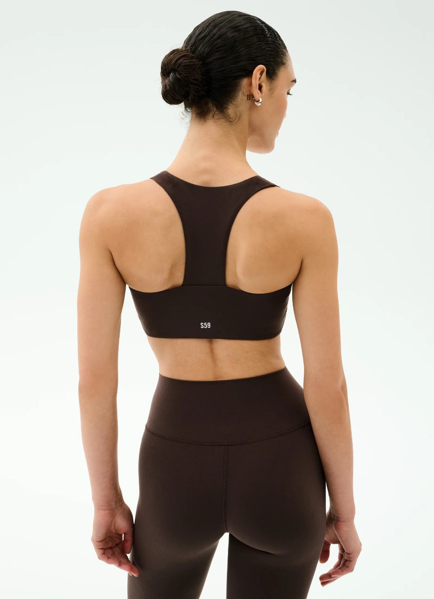 Woman wearing a black sports bra and leggings on a white background