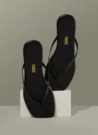TKEES Square Toe Lily Flip Flops in Black Shown in a Display