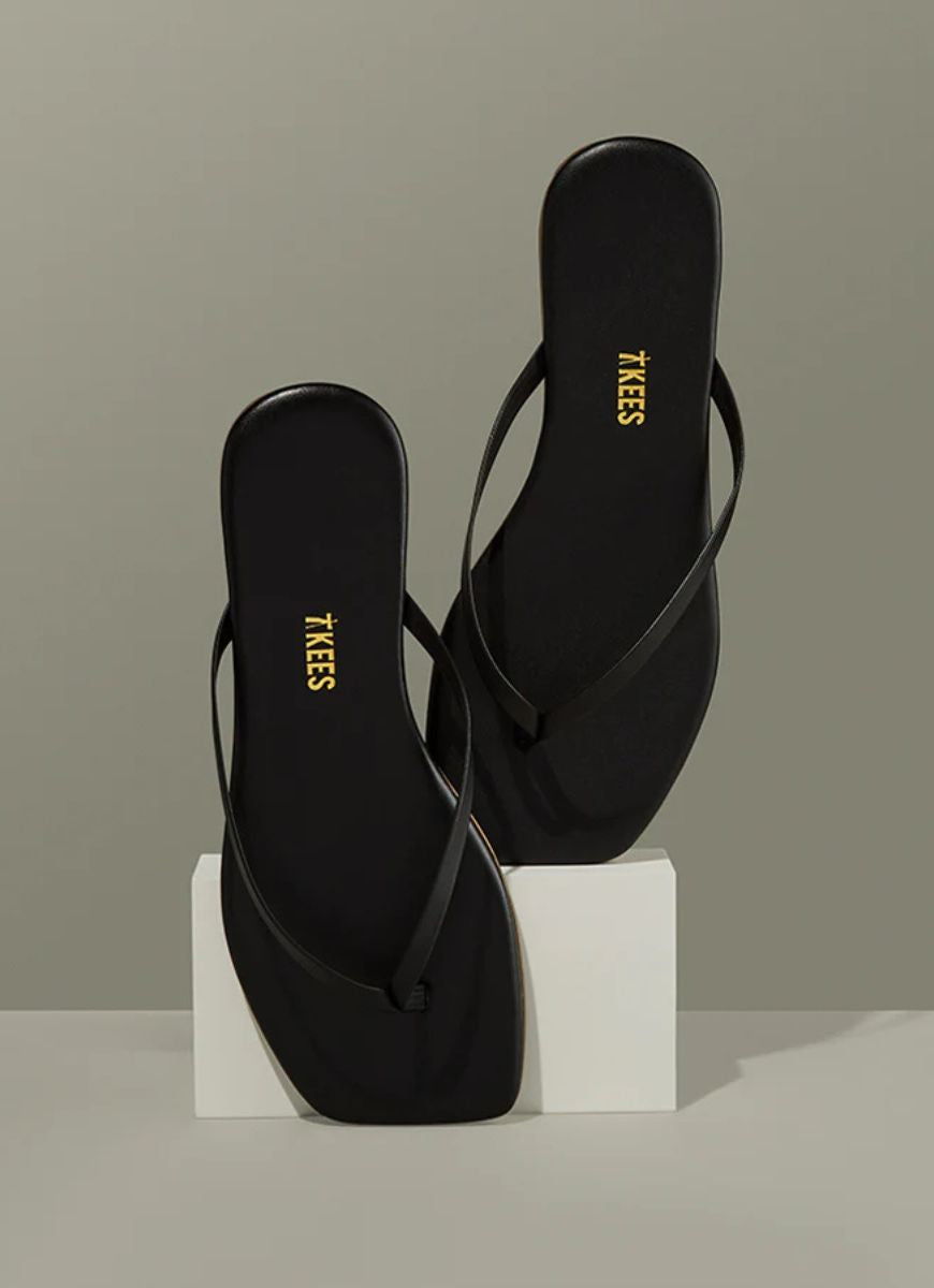 TKEES Square Toe Lily Flip Flops in Black Shown in a Display