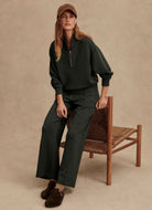 Varley Davidson Sweatshirt in Olive Marl Model Sitting on a Chair