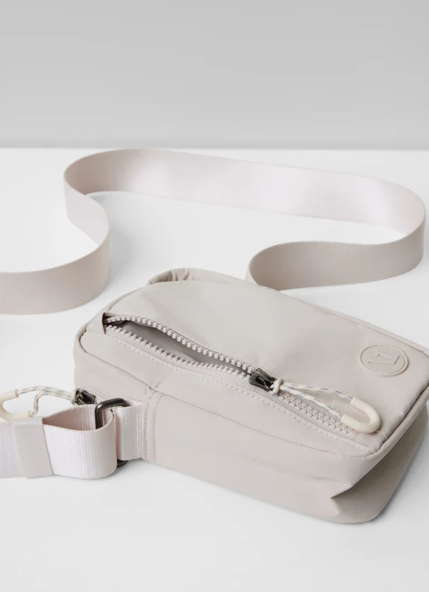 Vuori All Around Crossbody Bag in Ecru Displayed Laying Flat With Zipper Partially Unzipped