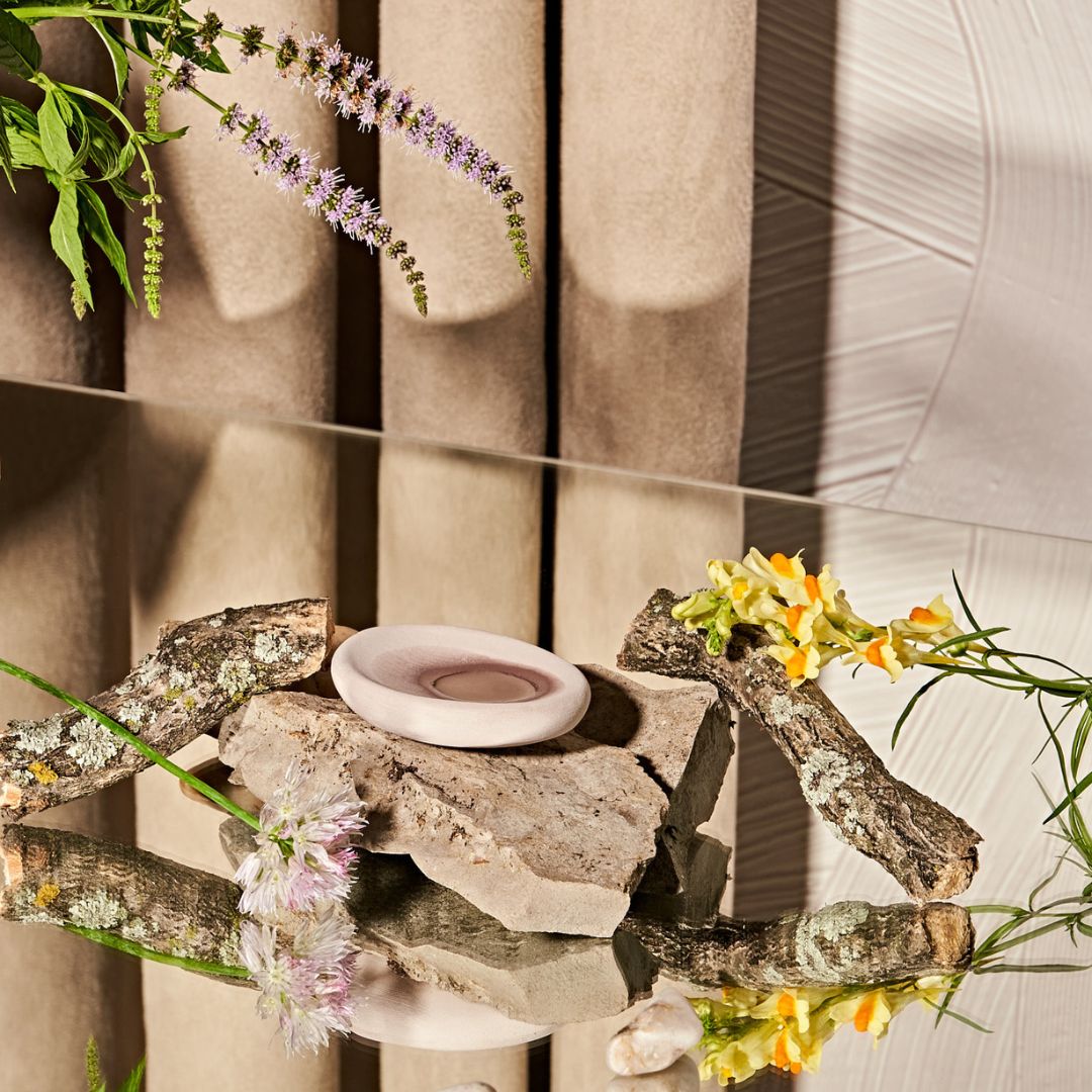 LOHN Scent Pebble Essential Oil Diffuser Pictured on a Stone on a Glass Table