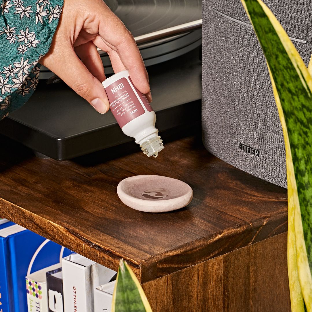 LOHN Scent Pebble Essential Oil Diffuser Model Shown Dropping Scented Liquid On Diffuser