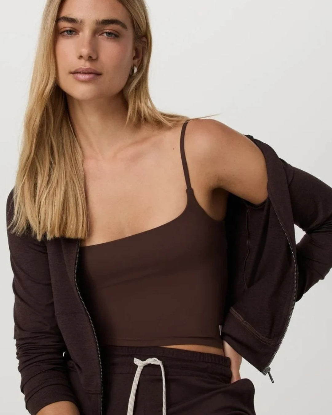 Women's chocolate brown athleisure outfit featuring a fitted tank, zip hoodie and relaxed pants from Vuori at relevé