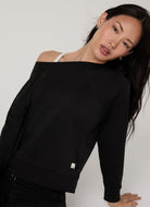 Vuori Women's Long Sleeve Halo Crew in Heather Black Front View With Model Leaning in a Pose