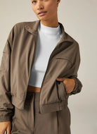 Beyond Yoga Status Pocket Sleeve Cropped Jacket in Dune Front View Unzipped