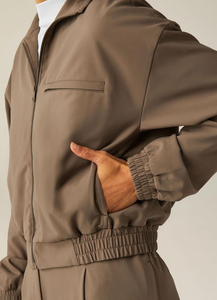 Beyond Yoga Status Pocket Sleeve Cropped Jacket in Dune Close Up View of Hand in Pocket