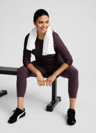 Beyond Yoga Spacedye Caught In The Midi High Waisted Legging Brilliant Blackberry Heather Model Sitting Down on a Workout Bench