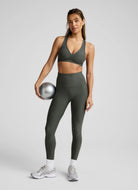 Beyond Yoga Spacedye Lift Your Spirits Sports Bra in Dusty Forest Heather Front View With Model Shown Holding a Ball