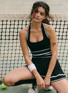 Free People Advantage Set in Black Combo Model Crouched Down on a Tennis Court