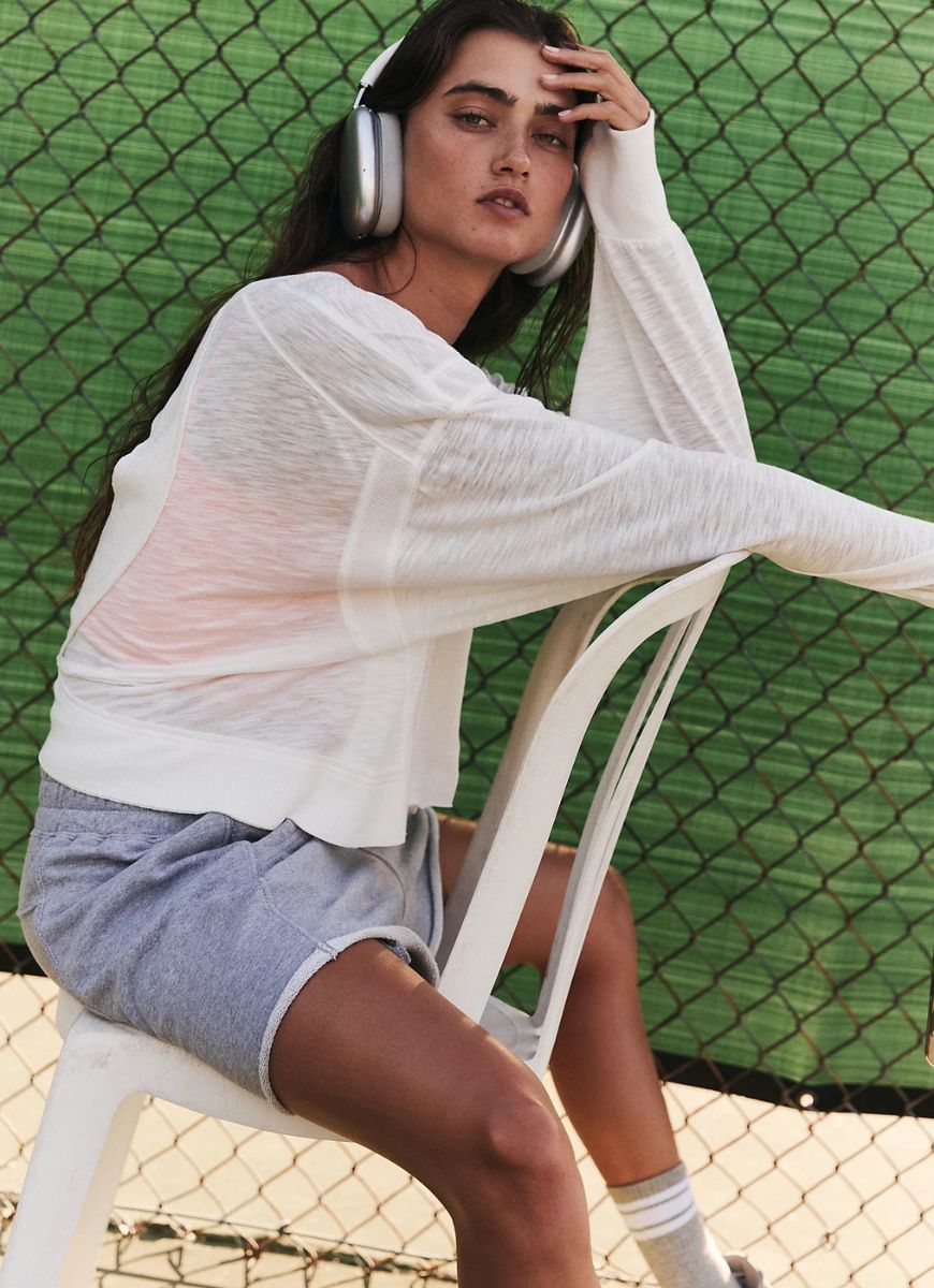 Free People My Time Layer Tee in White Model Sitting Down on a Chair on a Tennis Court
