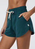 Vuori Women's Halo Performance Short 2.0 in Moss Heather Close Up Side View With Hand in Pocket