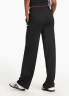 vuori Women's Halo Essential Wideleg Pant in Black Back View with Hands in Pockets