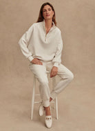 Varley Hawley Half Zip Sweat in Ivory Marl Model Sitting on a Stool