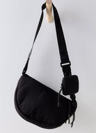 Free People Hit The Trails Sling Bag in Black Hanging on a Peg