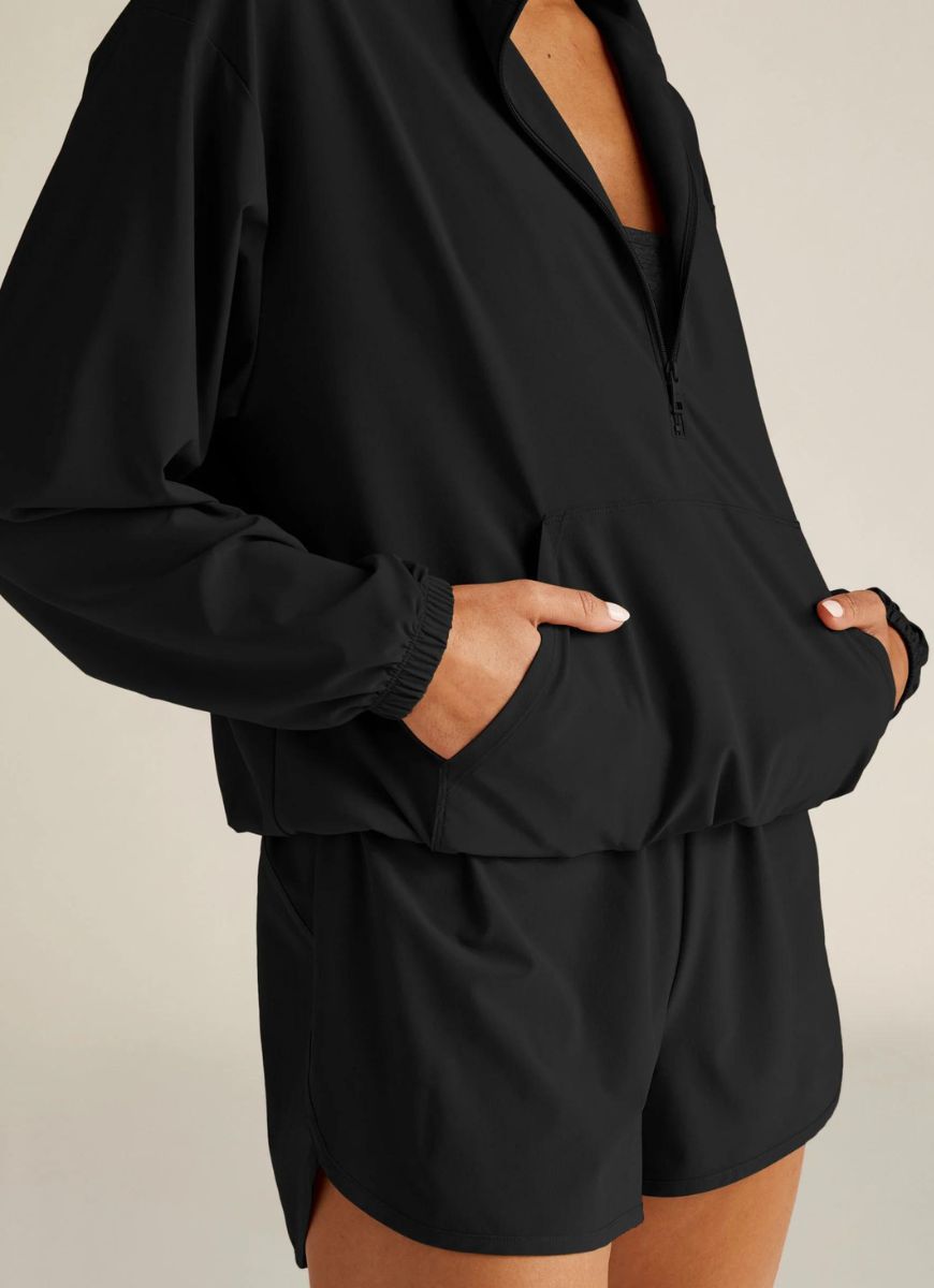 Beyond Yoga Stretch Woven In Stride Half Zip Pullover in Black Close Up View with Hands in Pockets