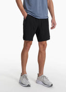 vuori Men's Kore Short in Black Angled Side View with Hand in Pocket