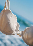 LSPACE Sunrise Shell Bikini in Cream Shown Hanging With Ocean in the Background