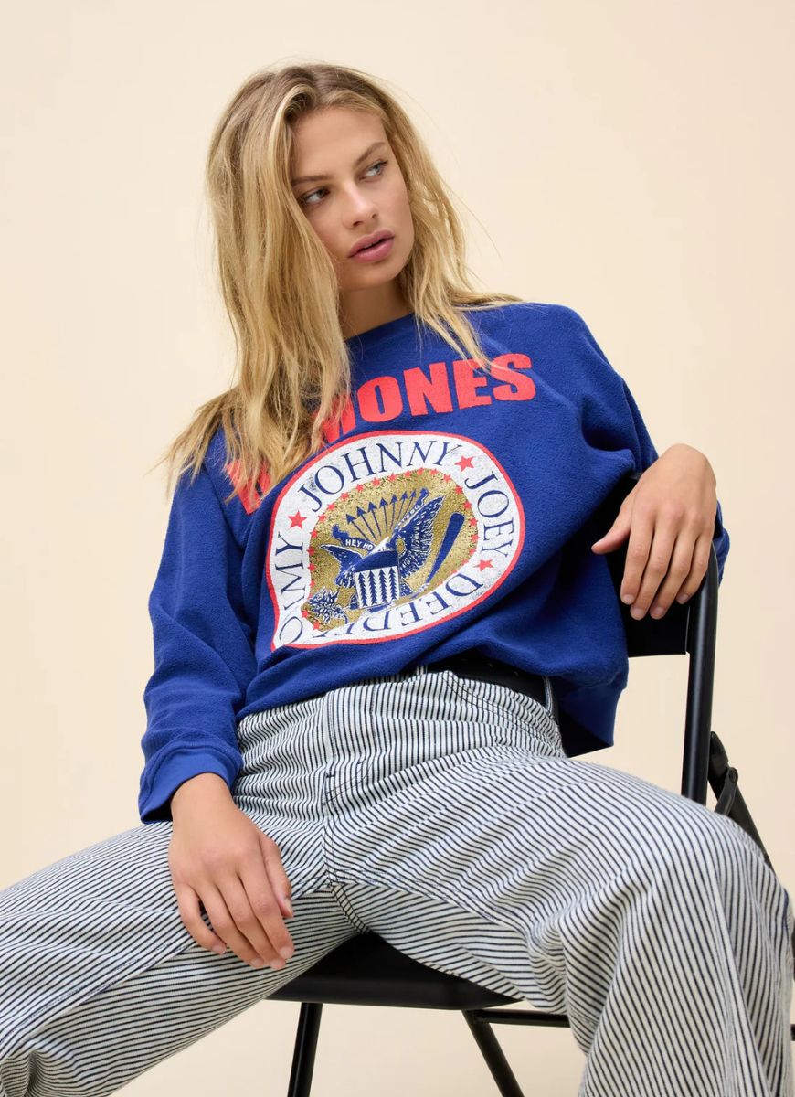 DAYDREAMER Ramones Gold Seal Reverse Crew Sweatshirt in Blue Quartz Model Sitting in a Chair