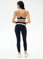 Woman wearing a sports bra and leggings on a white background