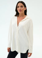 Woman wearing a white blouse with a plain background