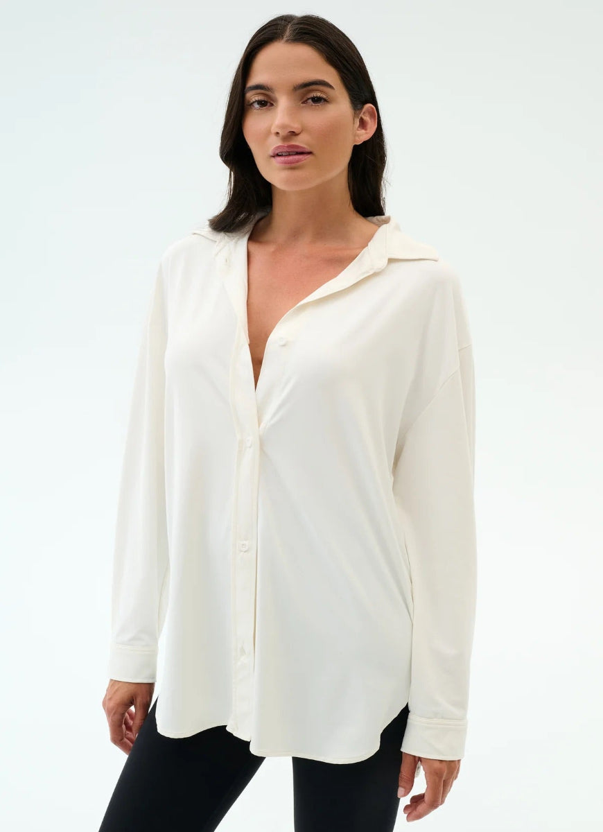 Woman wearing a white blouse with a plain background