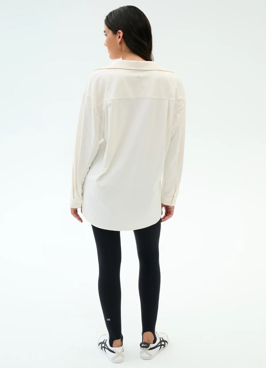 Woman wearing a white shirt and black leggings on a white background