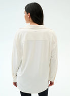 Woman wearing a cream-colored shirt on a white background