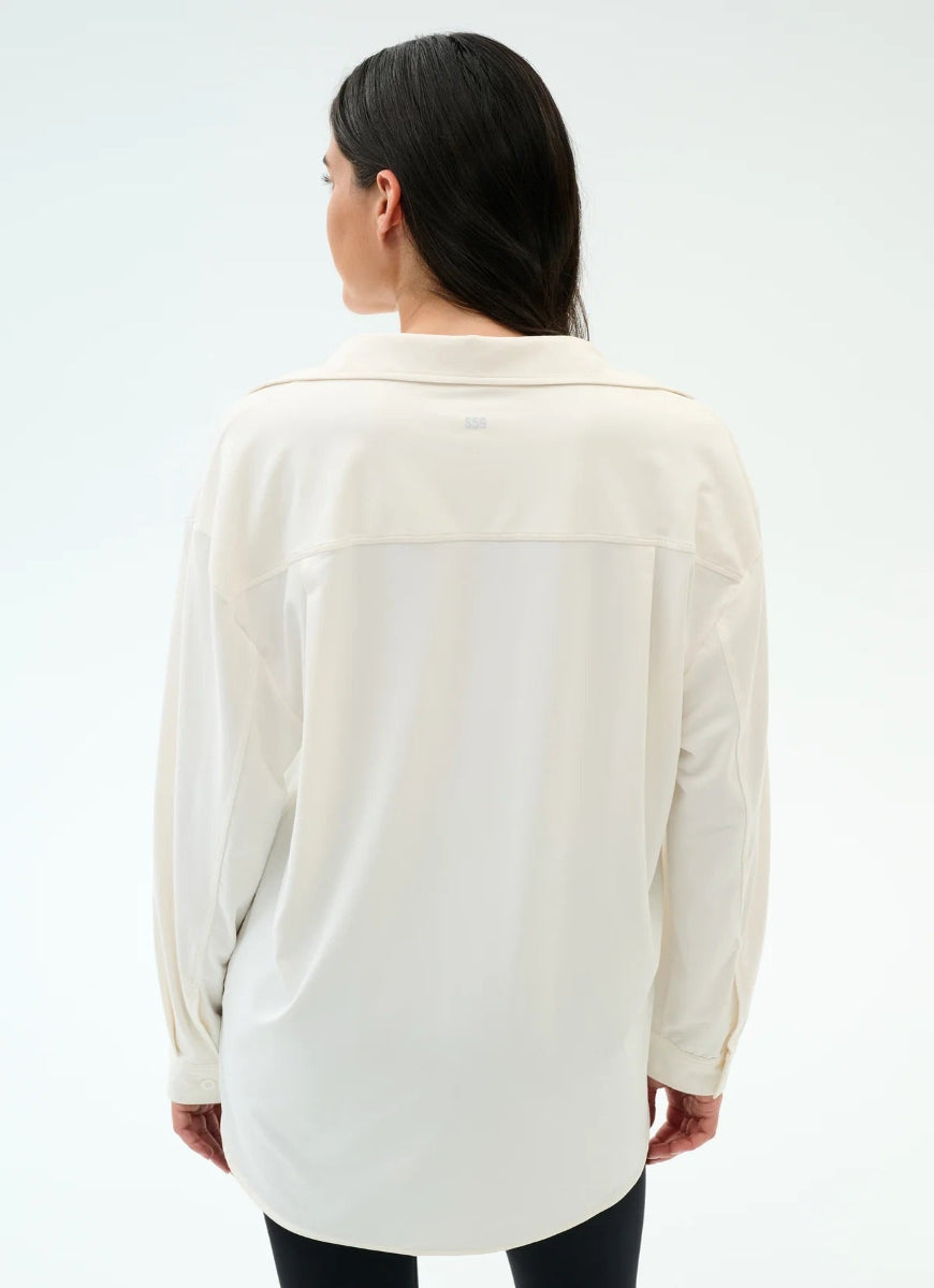 Woman wearing a cream-colored shirt on a white background