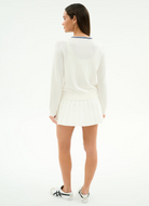 Woman wearing a white outfit with a skirt on a white background