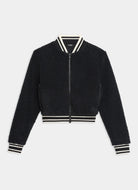 Black bomber jacket with white and black striped trim on a light gray background