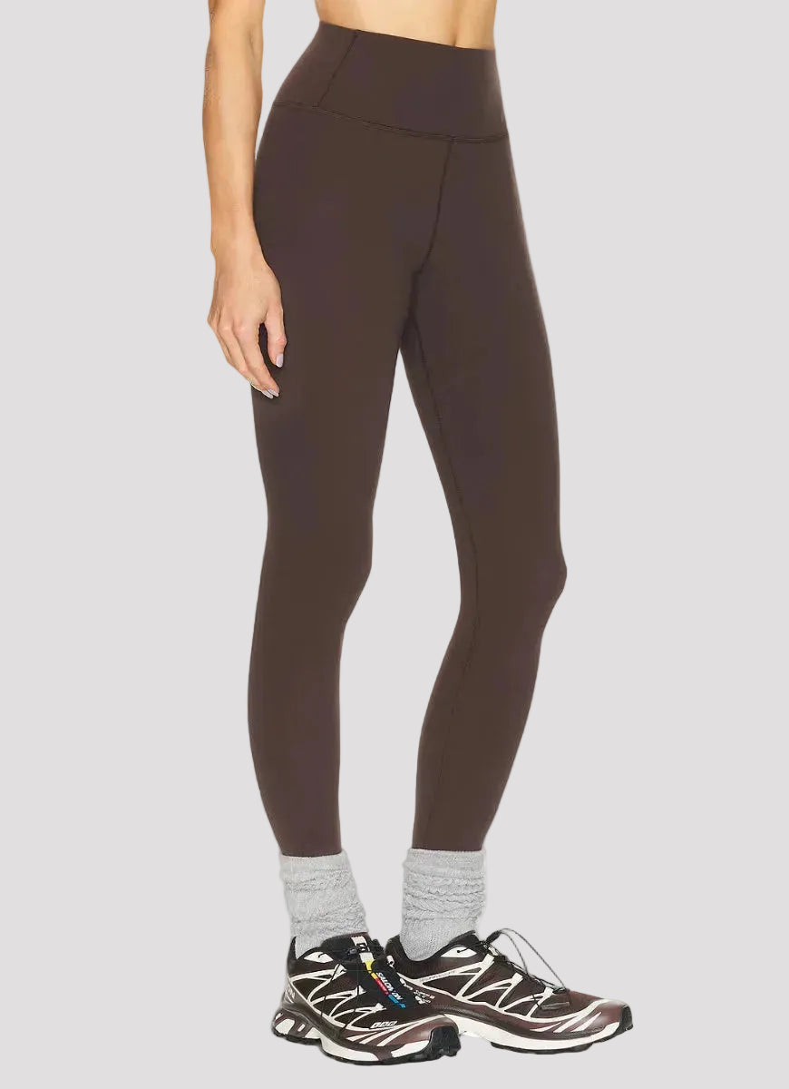Brown leggings worn by a person on a white background