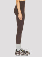 Brown leggings worn by a person on a white background