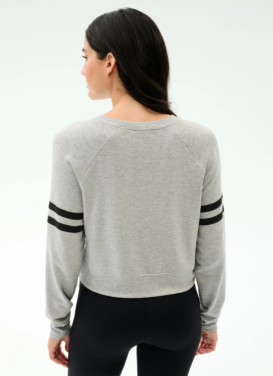 Woman wearing a gray sweater with black stripes on a white background